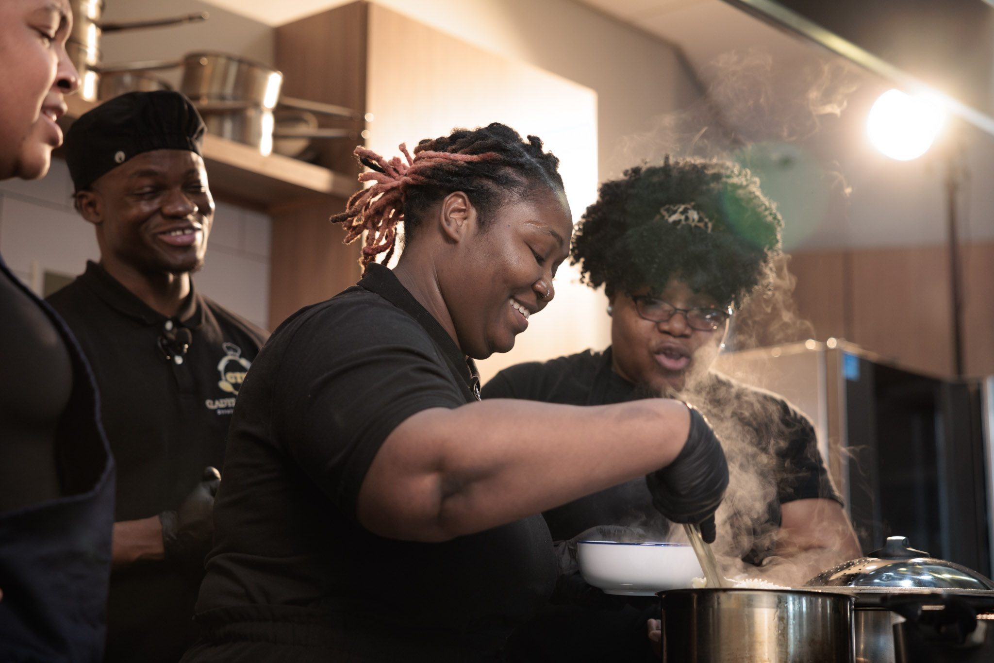 Schneider, his mom Sherly Joseph and Schneider's cousin all look into a pot on the stove.