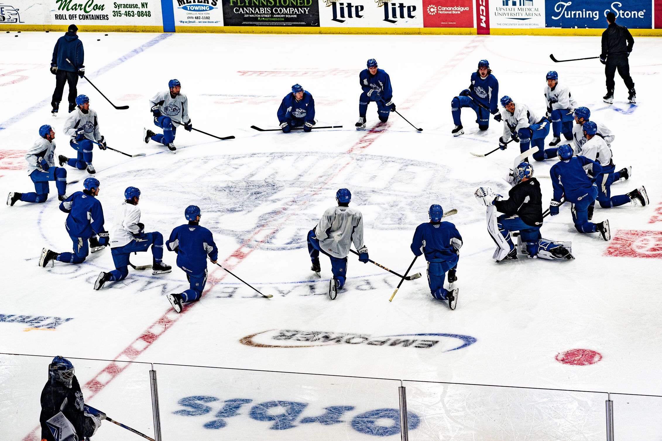 Members of Lightning’s American Hockey League affiliate team, the Crunch, kneel in a circle on the ice during practice.