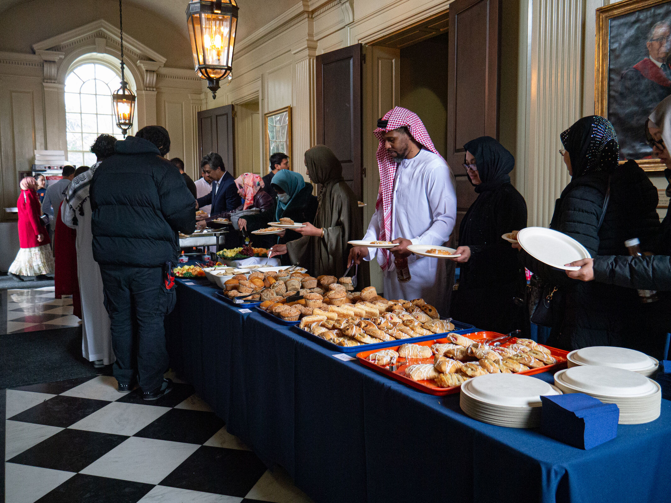 At the Eid service, patrons gather around a table filled with pastries.