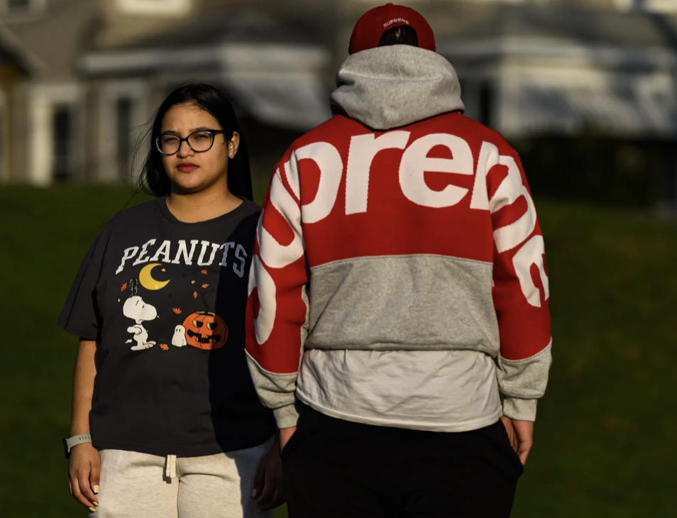 Rafael’s sister, Miranda, stands next to Rafael on a basketball court. She is facing the camera but he is turning his back.