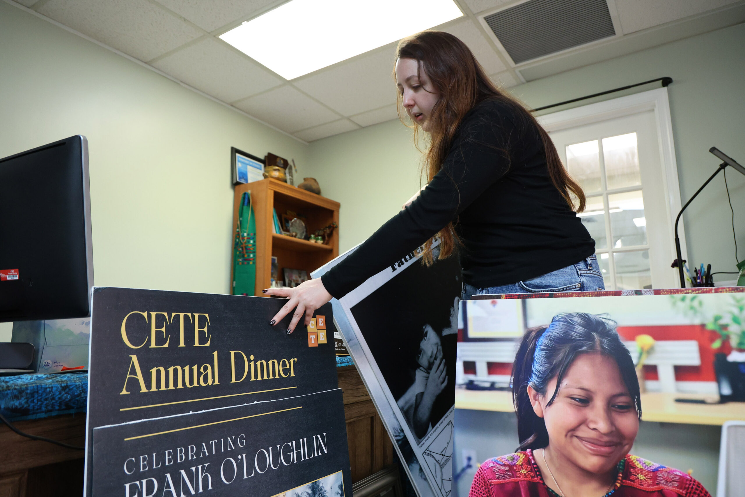 Lindsay McElroy, lead immigrant justice organizer at the Guatemalan Maya Center, which seeks to reunite families, in Lake Worth, shuffles through poster boards on display at the Center. Friday, February 13, 2026.