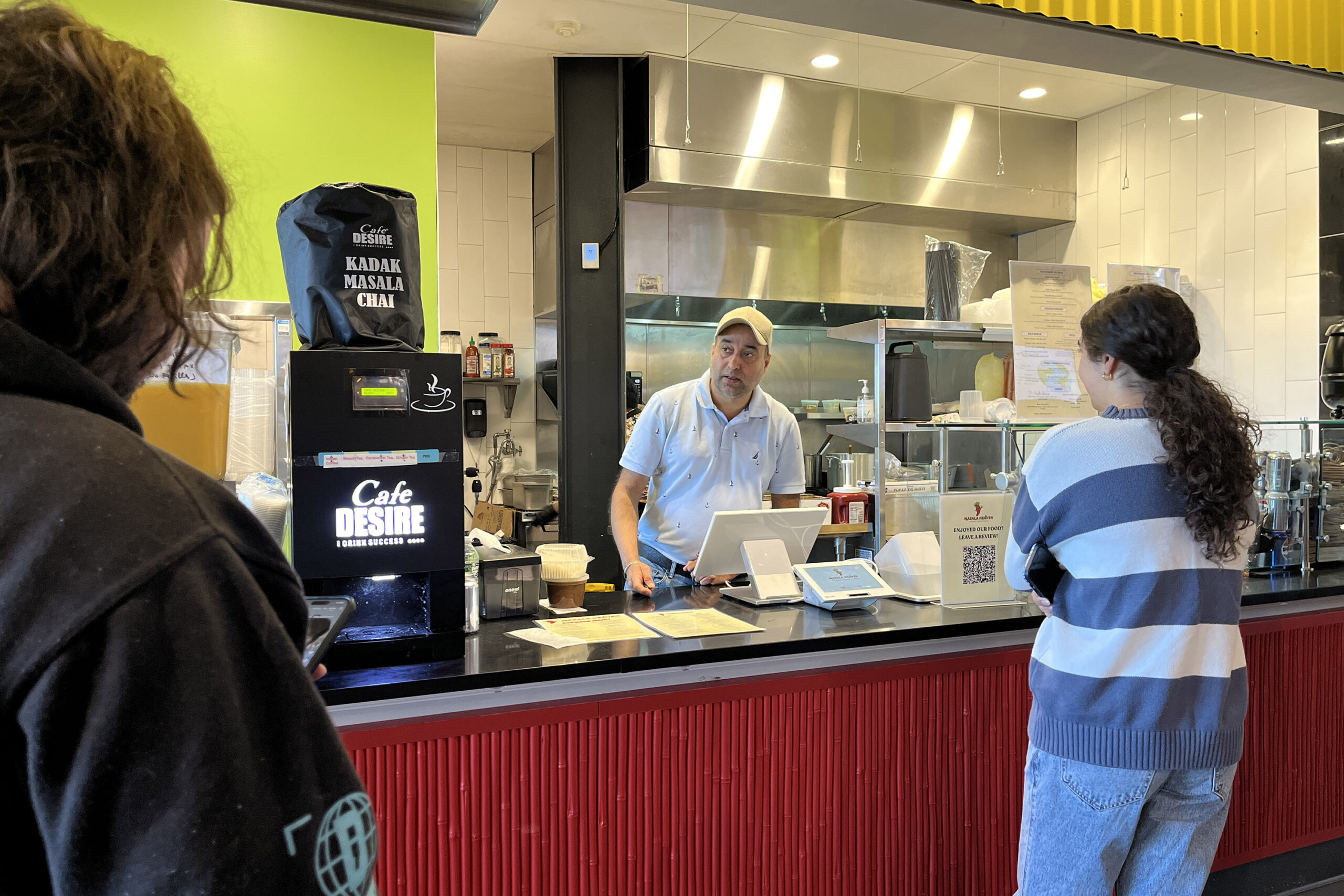 Gary Singh, owner of Masala Heaven, serves customers at the Salt City Market
