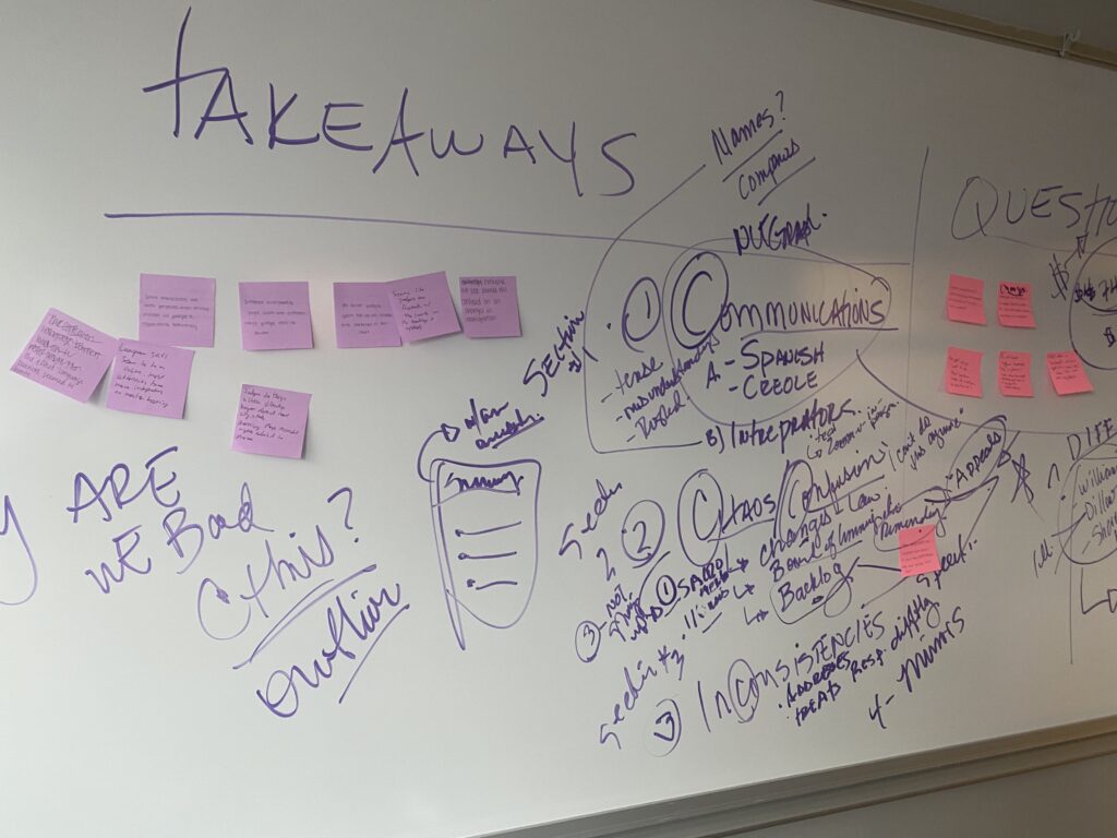 A whiteboard with purple handwriting and pink and purple sticky notes.