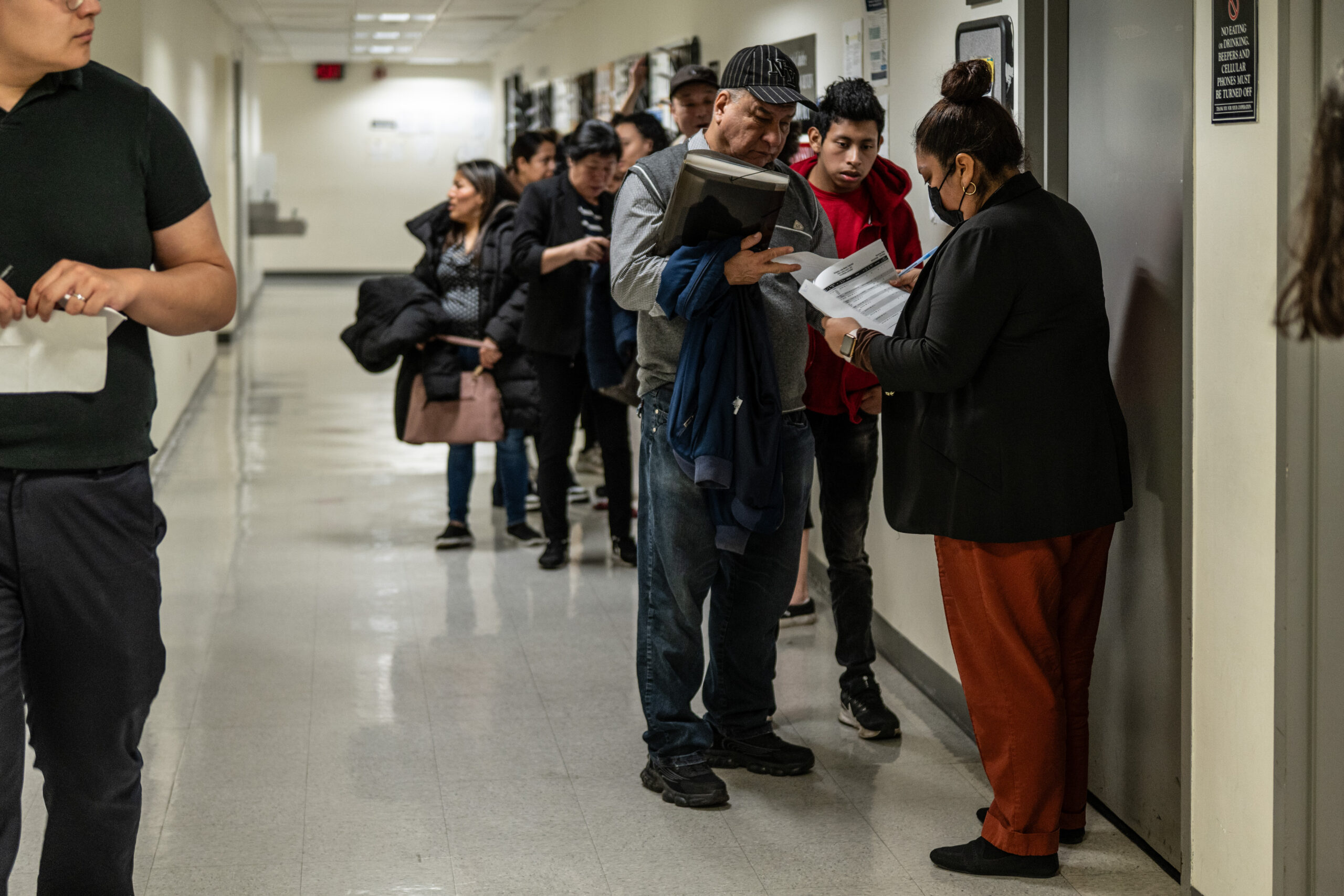 A man and his family ask a court worker for directions to their immigration check-in courtroom on the 12th floor of the Jacob K. Javits Federal Building in New York on March 9, 2026. The building and the neighboring Ted Weiss Federal Building together house more than seven floors of courtrooms, and immigrants with limited English proficiency can face difficulty navigating between the two.