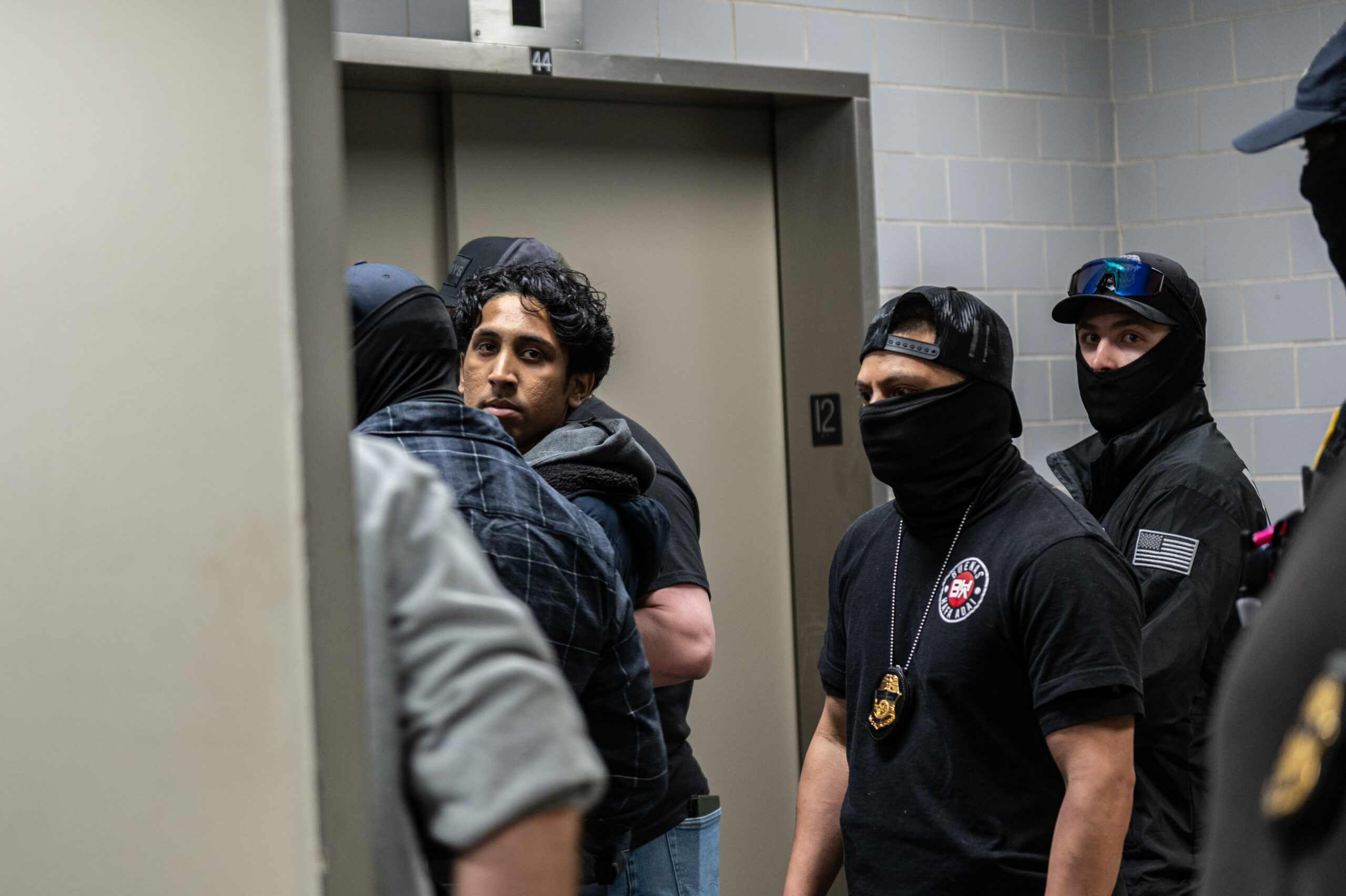 A young man is detained inside a restricted elevator area at 26 Federal Plaza in New York on March 10, 2026.