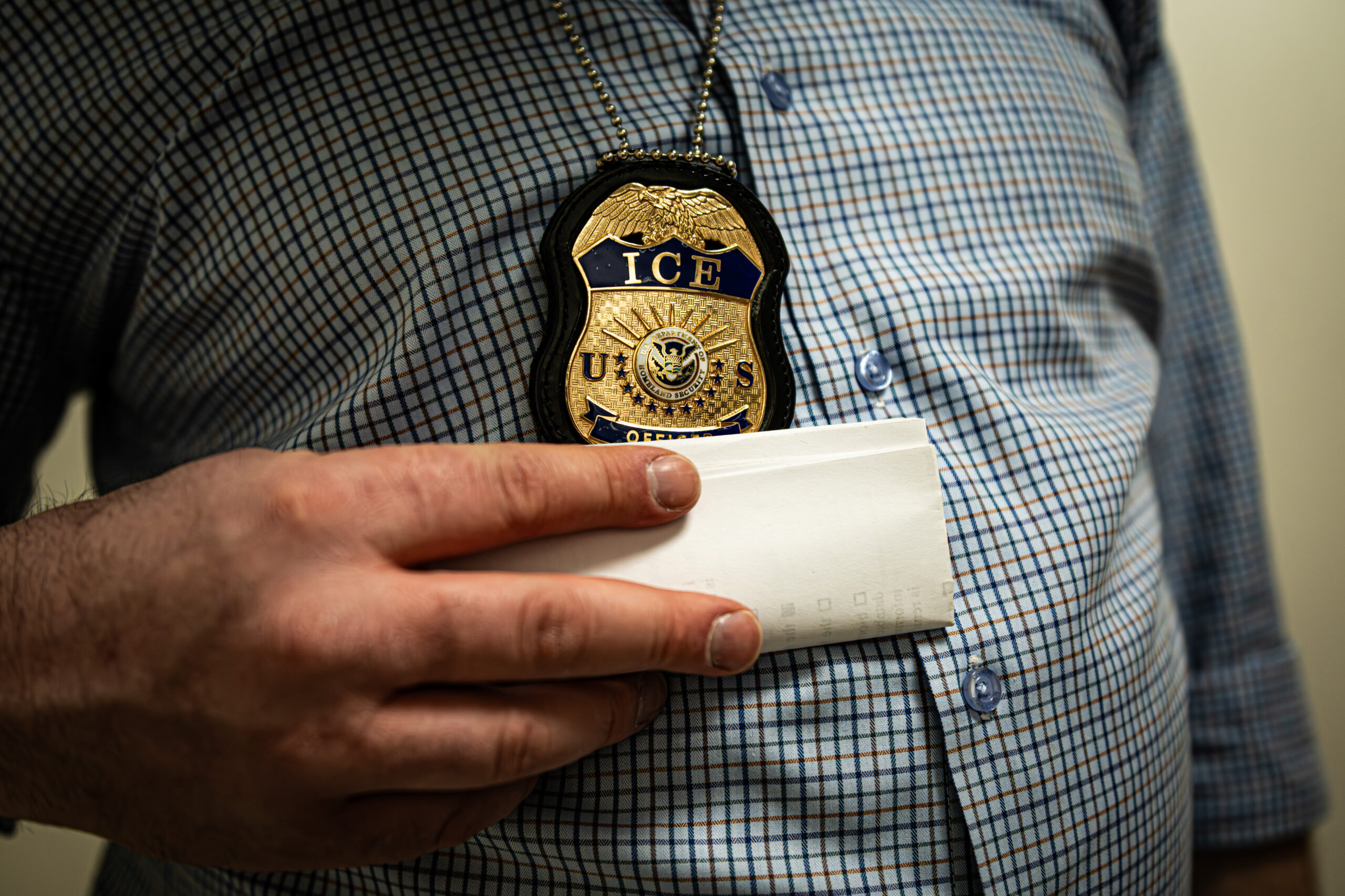 An Immigration and Customs Enforcement agent obscures their badge number inside the Jacob K. Javits Federal Building in New York on March 10, 2026.