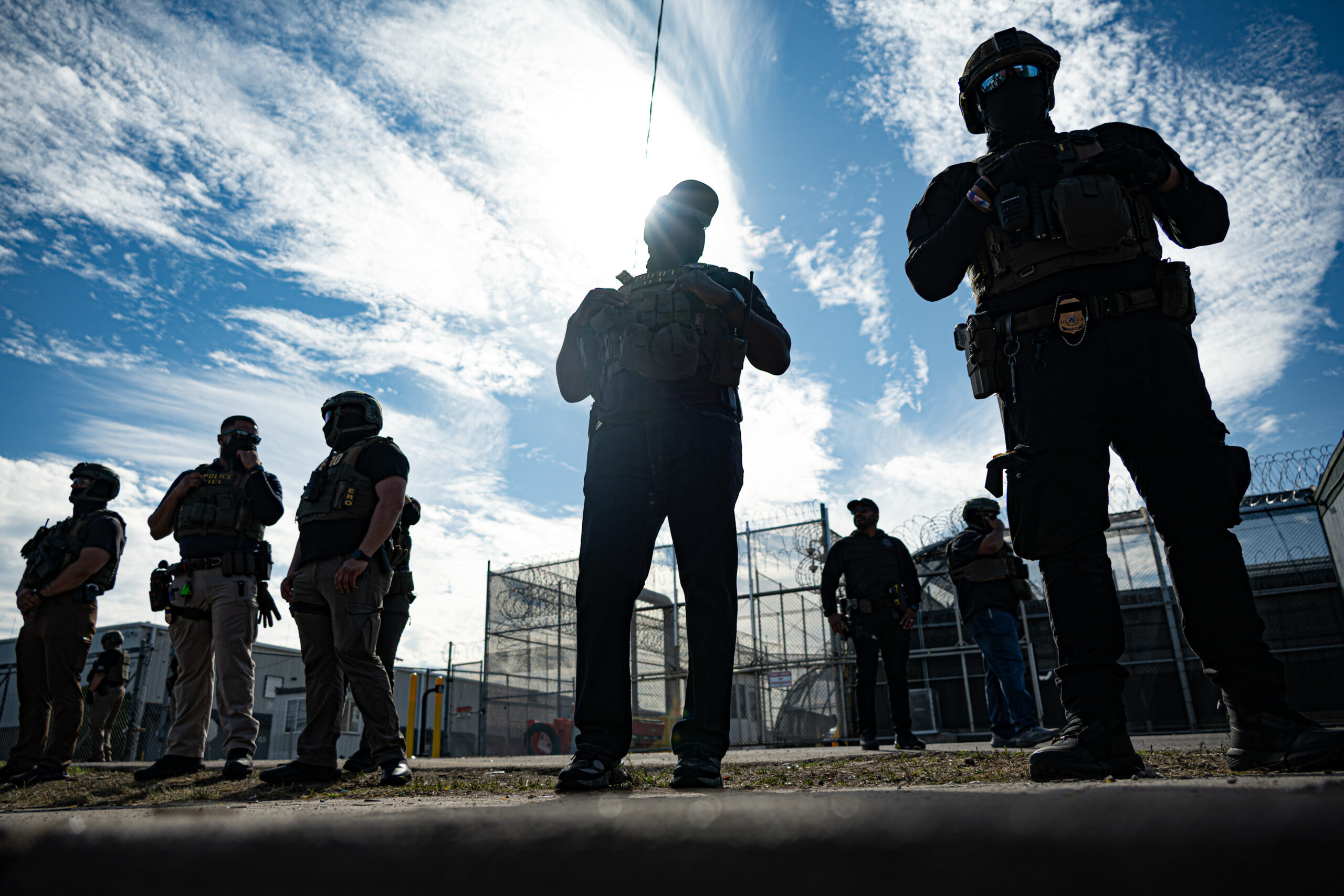 Federal agents guard two driveways leading to the vehicle bay of Delaney Hall detention center in Newark, N.J., on May 26, 2026. Agents created a secondary makeshift entrance on an adjacent dirt hill to manage traffic amid sustained protests at the facility.