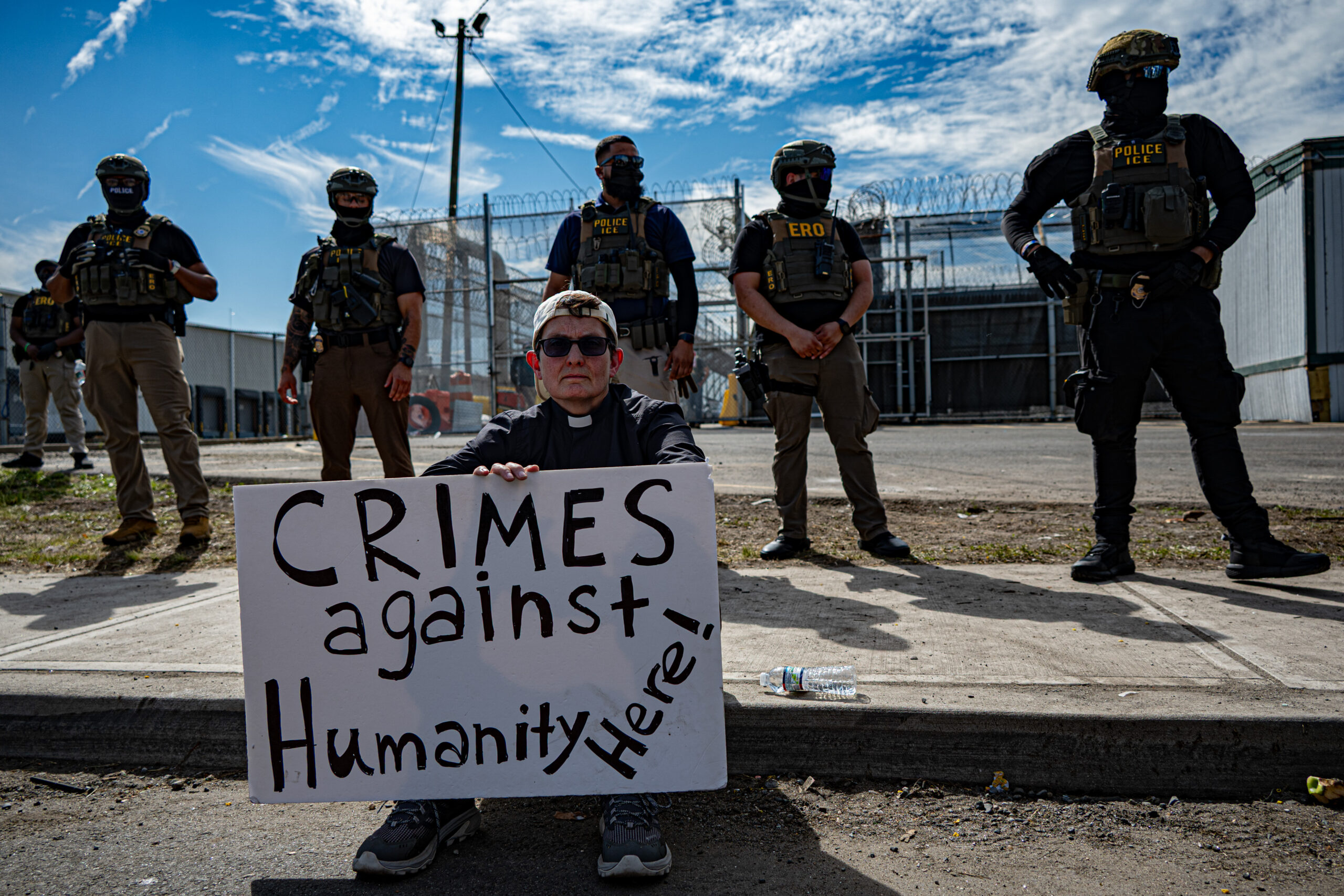The Rev. Dr. Dorothee Benz protests outside Delaney Hall detention center in Newark, N.J., on May 26, 2026, as demonstrators line the sidewalk in an effort to impede ICE vehicle traffic at the facility.