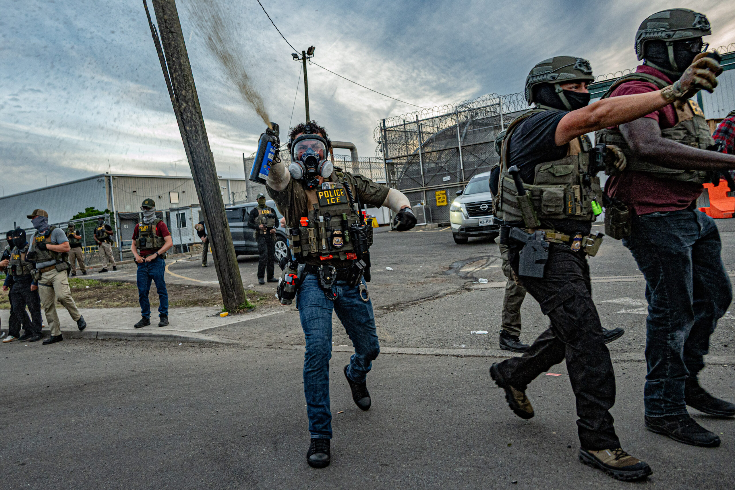 ICE agents advance on a crowd while deploying mace to clear a path for vehicles exiting Delaney Hall detention center in Newark, N.J., on May 26, 2026.