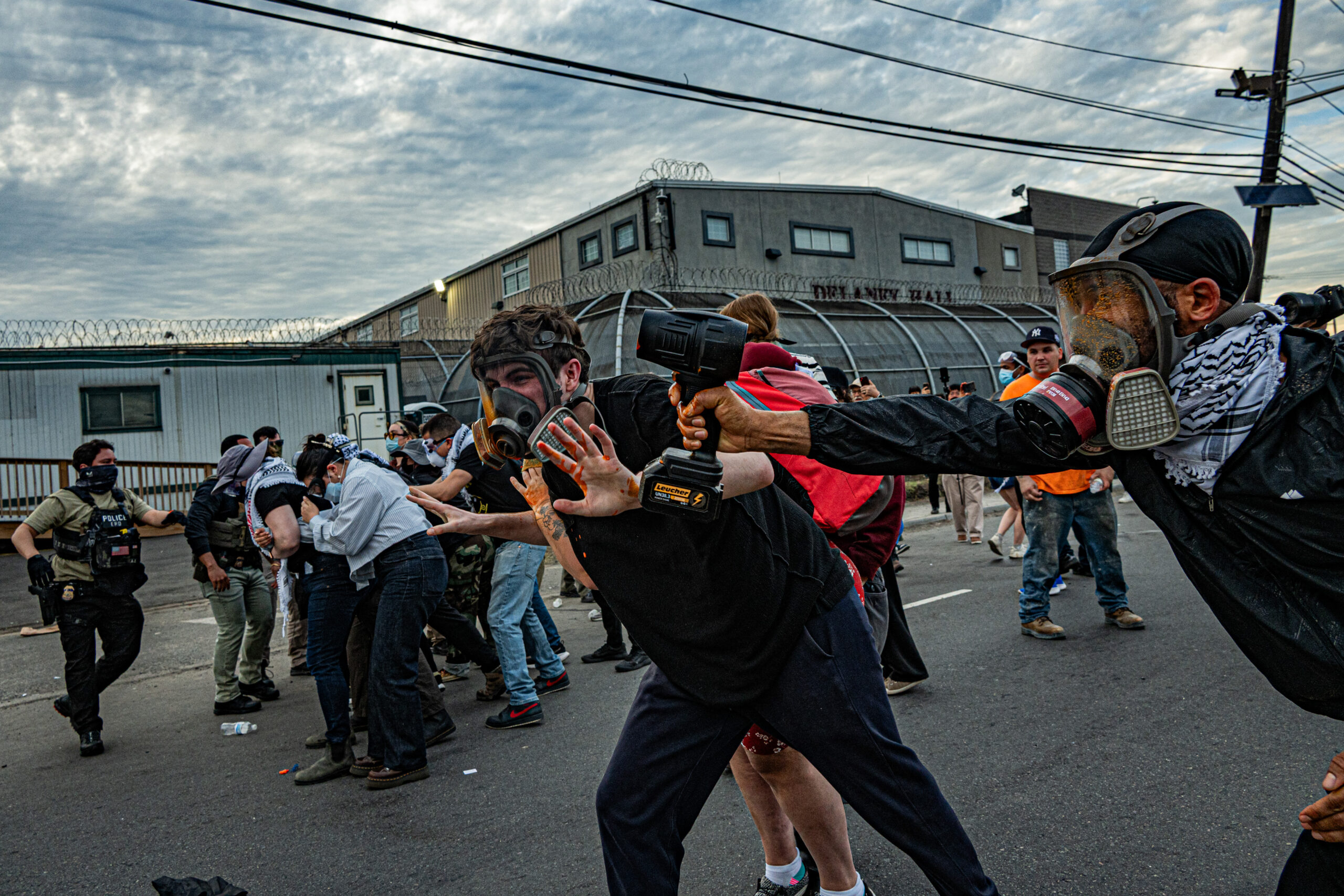 Protesters use hair dryers in an attempt to disperse chemical irritants deployed by federal agents outside Delaney Hall detention center in Newark, N.J., on May 26, 2026.
