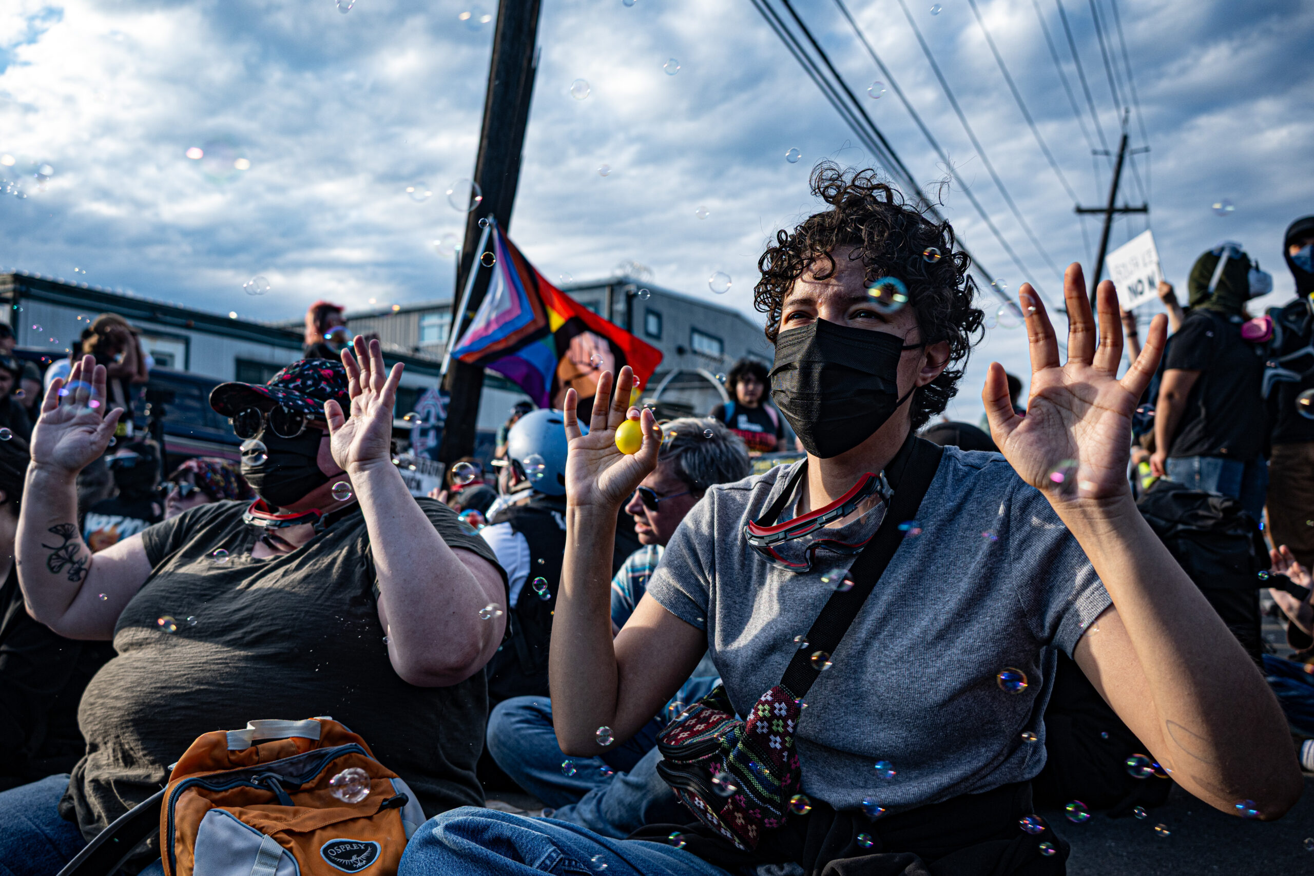 Rae Guthrie, left, and Cassie Montelongo sit in front of a driveway at Delaney Hall detention center to protest what demonstrators describe as inhumane treatment of detainees in Newark, N.J., on May 29, 2026.