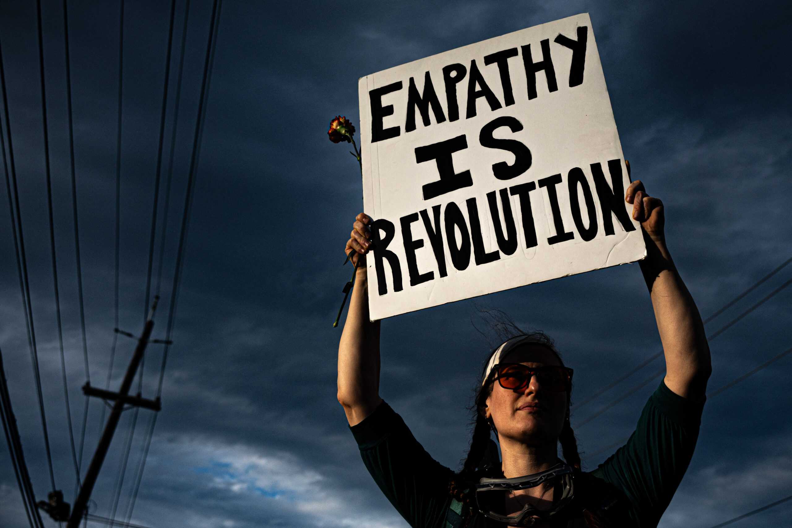 A protester holds a sign and a rose outside Delaney Hall detention center in Newark, N.J., on May 29, 2026.