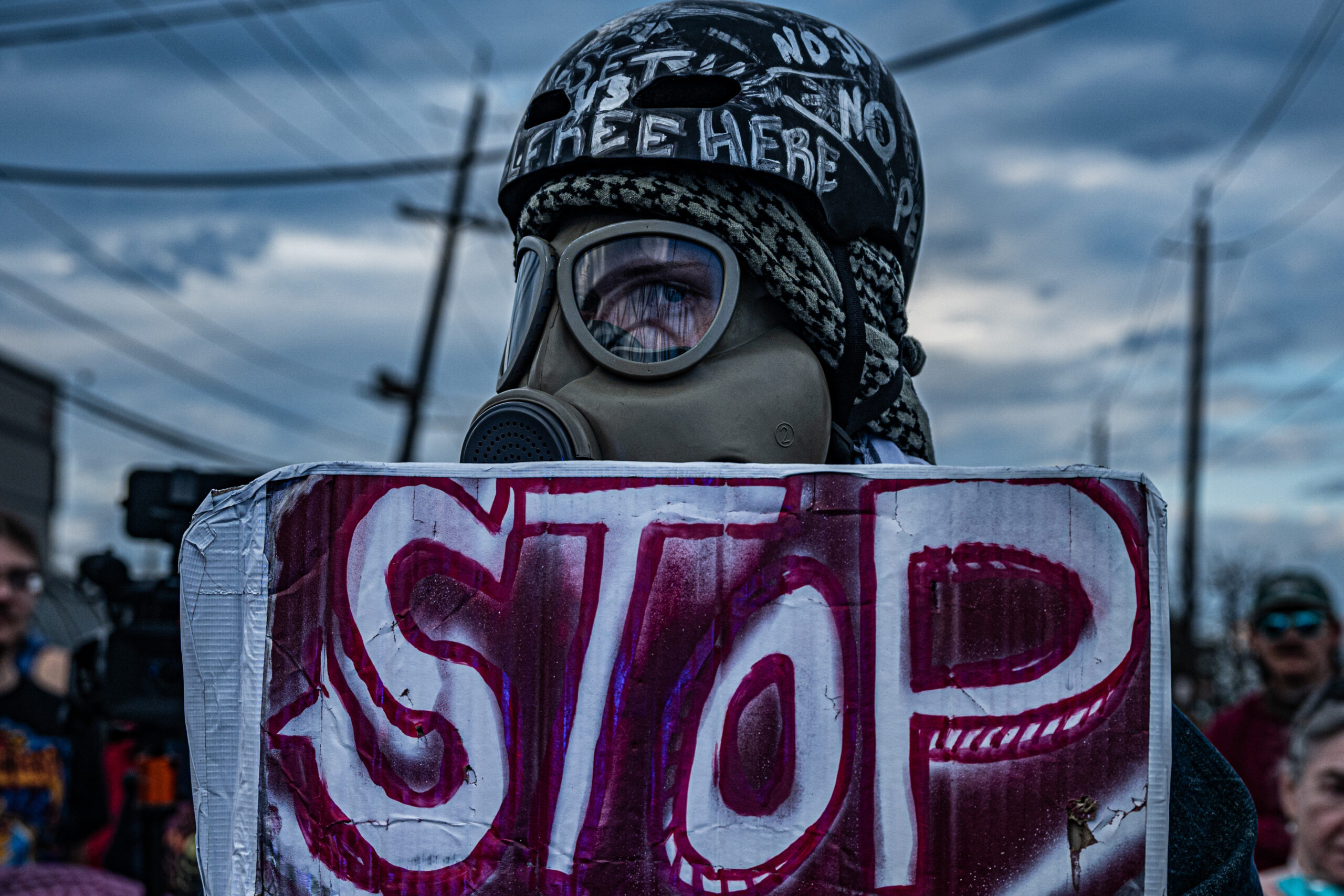 A protester wearing a military-grade gas mask stands at the entrance to Delaney Hall detention center in Newark, N.J., on May 29, 2026.