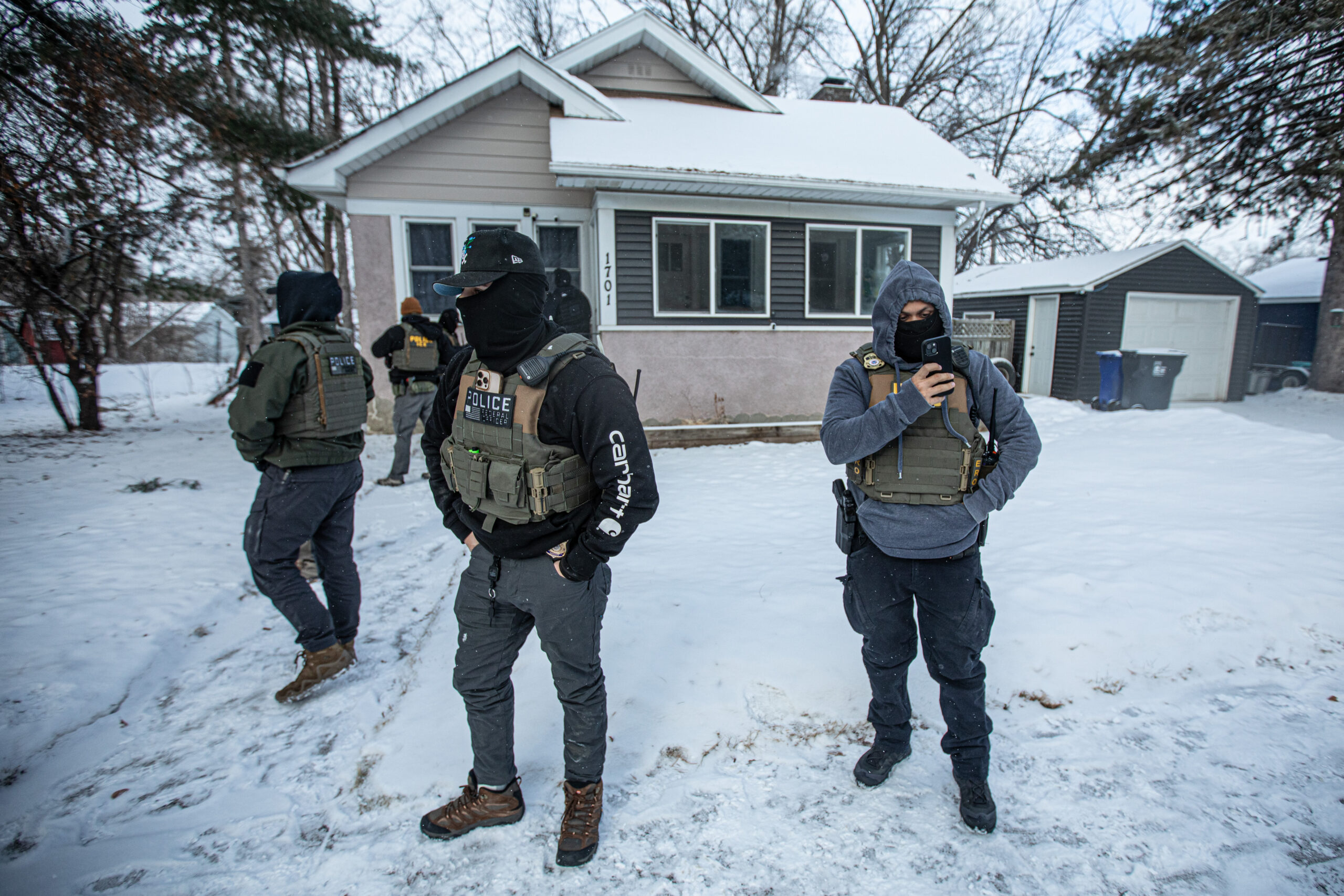 ICE and Enforcement and Removal Operations agents crowd the walkway of a home in St. Paul during an attempted raid on Jan. 18, 2026. Each ERO team includes at least one Spanish-speaking agent. At this location, the target had evacuated their children and left the home approximately 30 minutes before agents arrived.