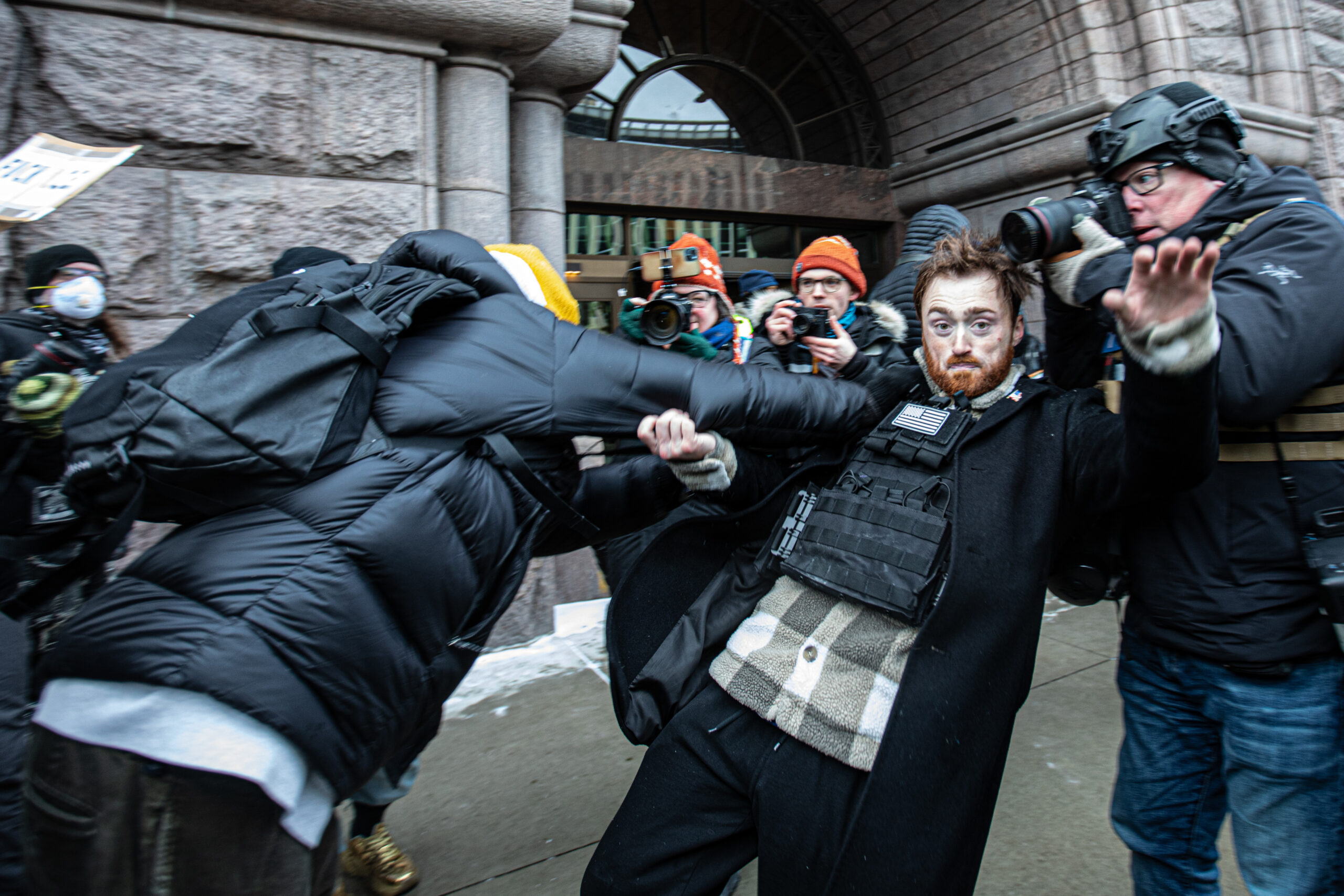 A far-right demonstrator who arrived with Jake Lang is shoved into a journalist in Minneapolis on Jan. 17, 2026.