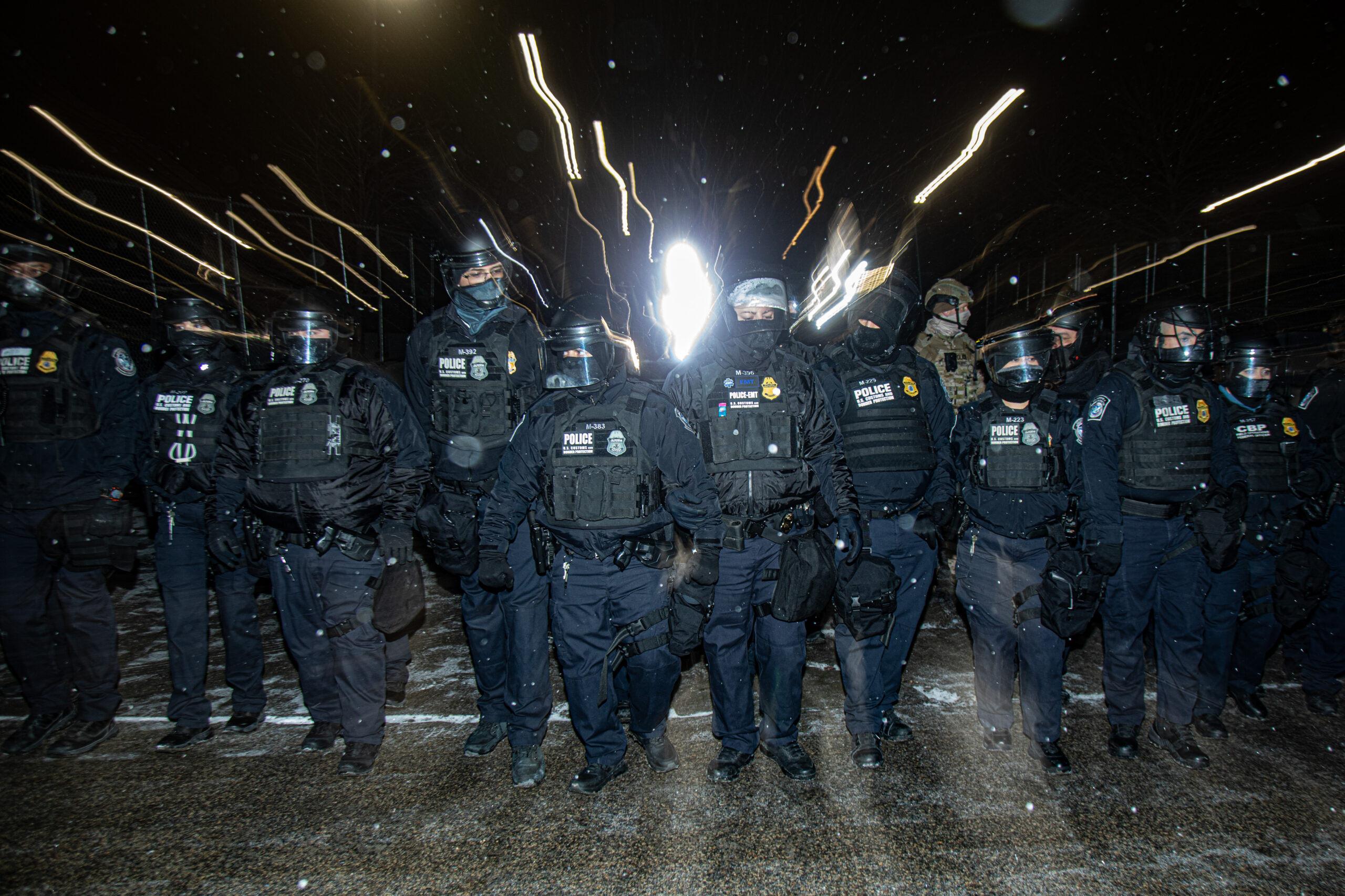 U.S. Customs and Border Protection officers advance toward a line of protesters outside the Whipple Federal Building in Fort Snelling, Minn., on Jan. 16, 2026. The confrontation resulted in at least one arrest.
